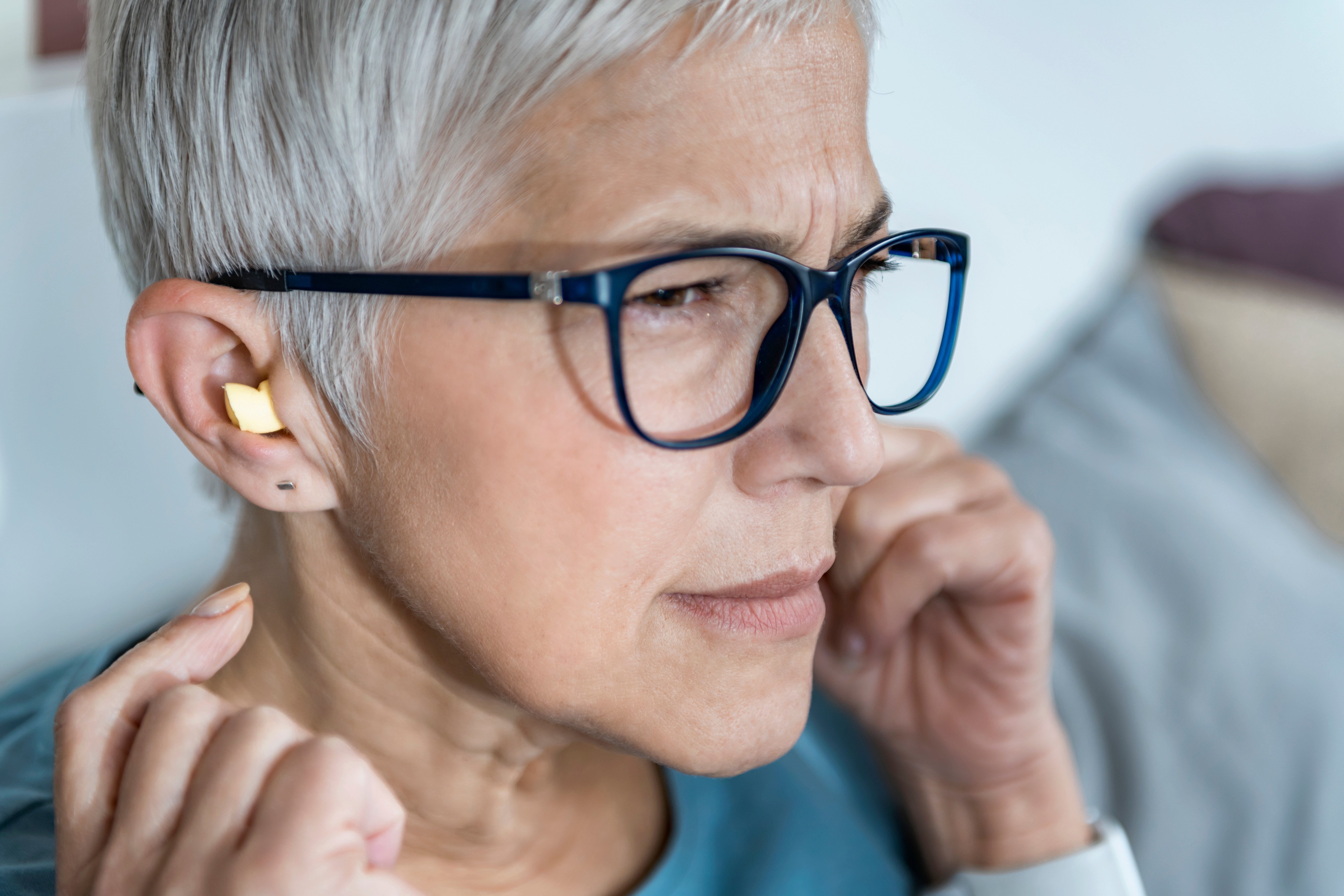 mature-woman-using-earplugs-for-sleeping-6TNMSUY